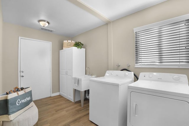 washroom with light wood-type flooring and separate washer and dryer