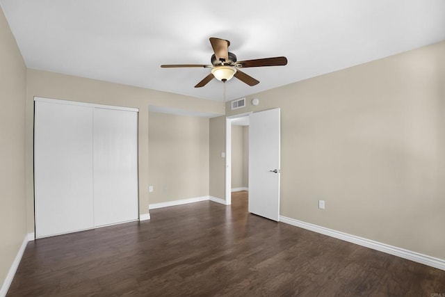 unfurnished bedroom featuring dark hardwood / wood-style flooring, a closet, and ceiling fan