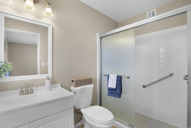 bathroom with toilet, an enclosed shower, and vanity