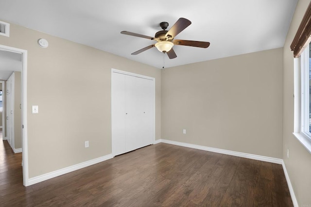 unfurnished bedroom featuring ceiling fan, dark wood-type flooring, and a closet