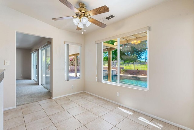 tiled empty room with ceiling fan and a healthy amount of sunlight