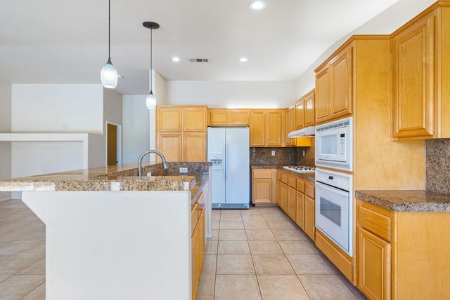 kitchen with light tile patterned floors, decorative backsplash, white appliances, pendant lighting, and sink