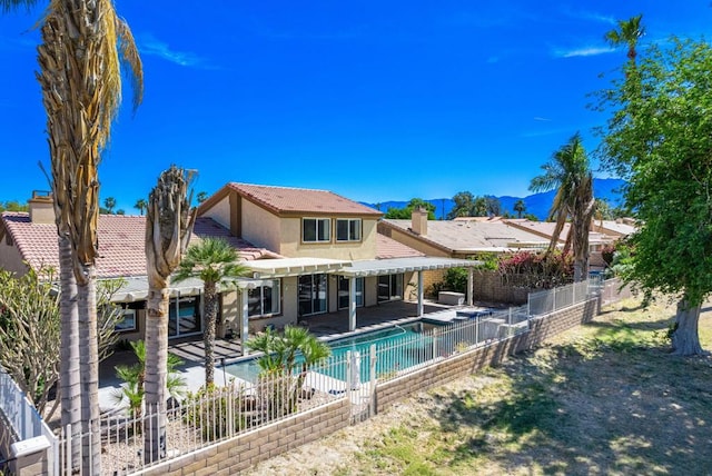 back of house with a fenced in pool and a patio