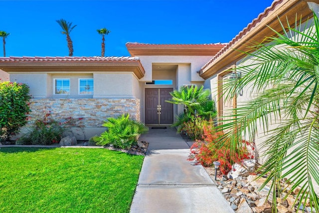 property entrance with a lawn