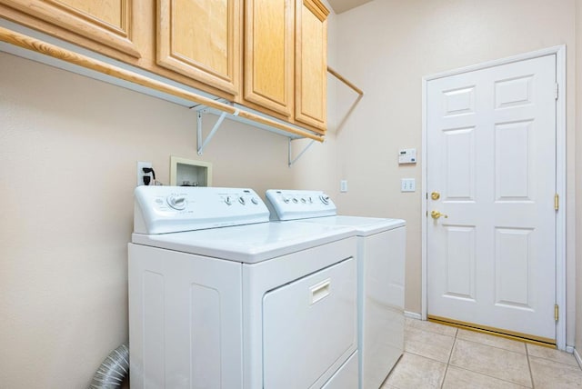 clothes washing area featuring cabinets, light tile patterned floors, and independent washer and dryer