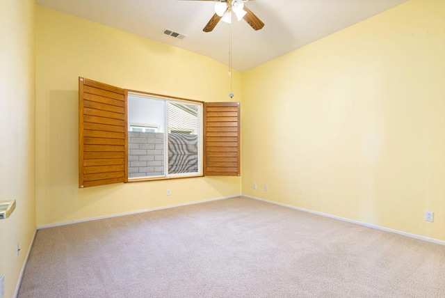 carpeted empty room featuring ceiling fan and vaulted ceiling