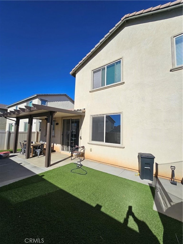 rear view of house with a pergola, a yard, and a patio