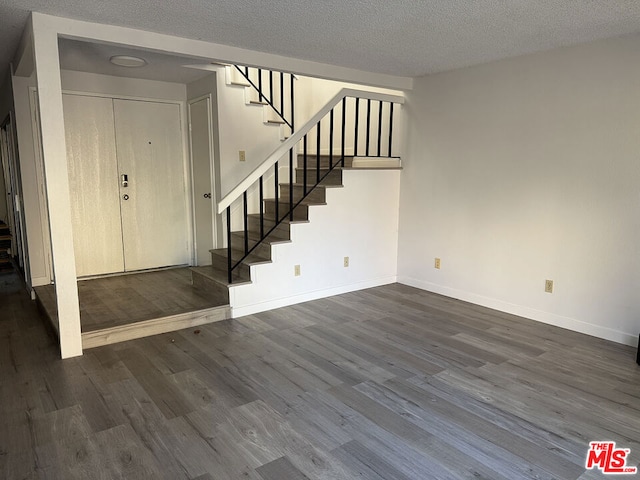 foyer with a textured ceiling and dark wood-type flooring