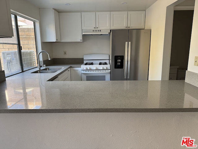 kitchen featuring sink, white gas range oven, stainless steel fridge with ice dispenser, white cabinetry, and kitchen peninsula