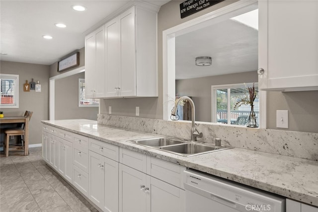 kitchen featuring light stone counters, sink, white cabinets, and dishwasher