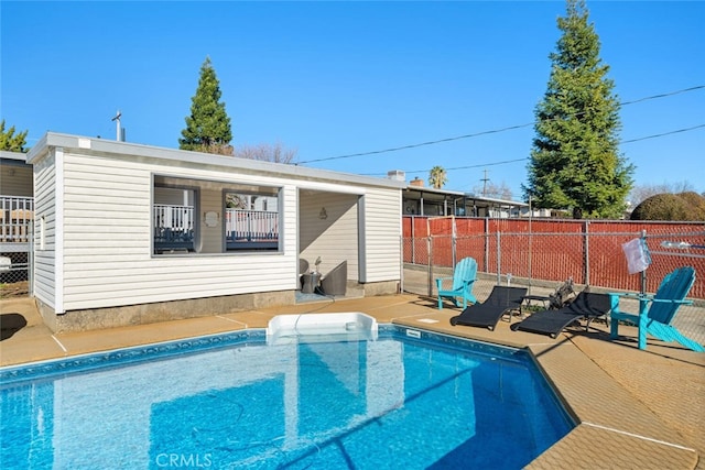 back of property with a fenced in pool