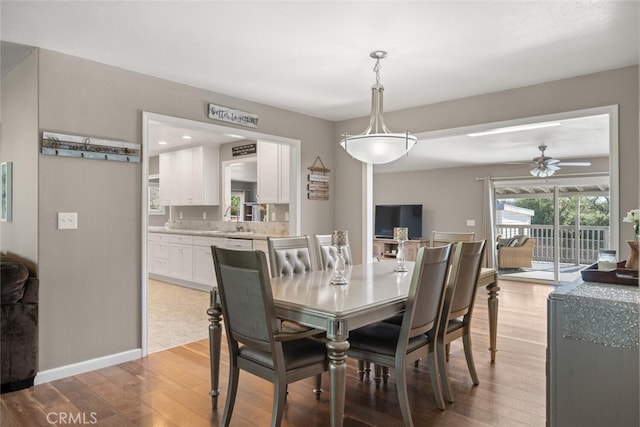 dining space featuring ceiling fan, sink, and light hardwood / wood-style flooring