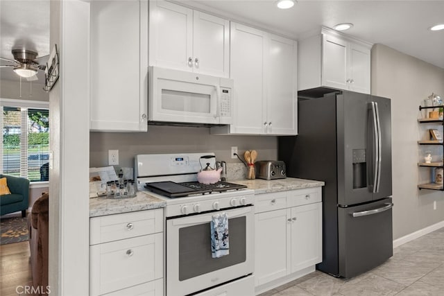 kitchen featuring white cabinets, white appliances, ceiling fan, and light stone countertops