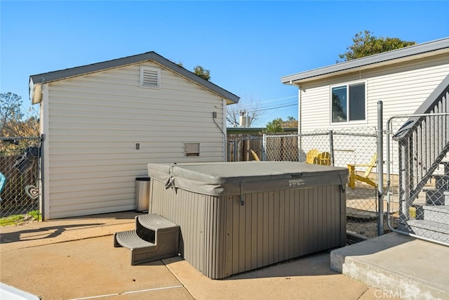 view of home's exterior featuring a patio area, a hot tub, and fence