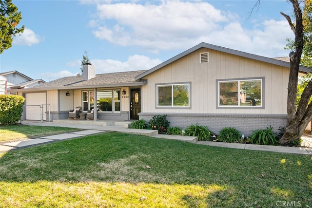 single story home featuring brick siding, a chimney, a front lawn, and a gate