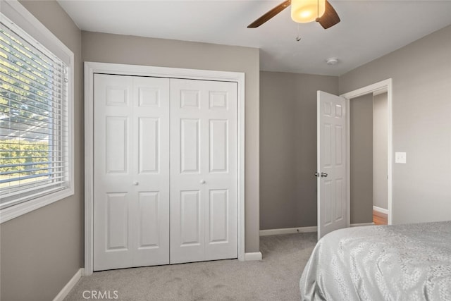 bedroom featuring ceiling fan, light colored carpet, and a closet