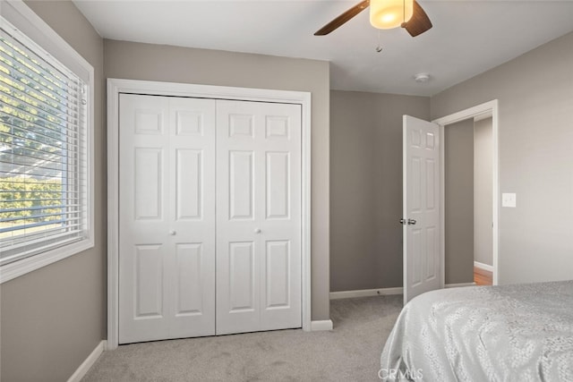 carpeted bedroom with baseboards, a closet, and ceiling fan