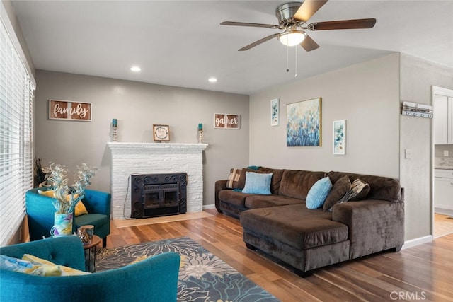 living room with a fireplace with flush hearth, wood finished floors, recessed lighting, and baseboards