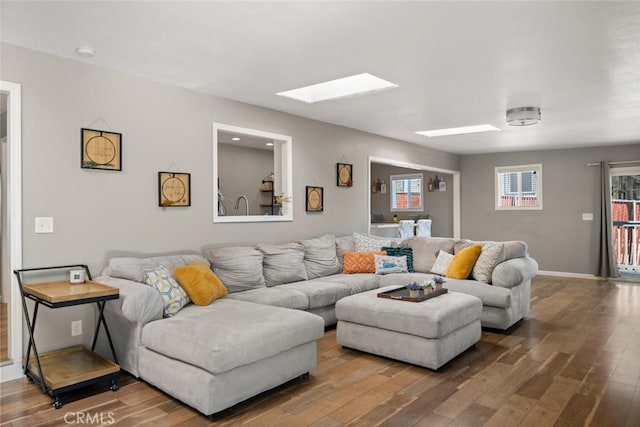 living room featuring a skylight and hardwood / wood-style flooring