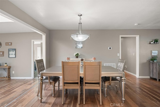 dining space with visible vents, baseboards, and wood finished floors