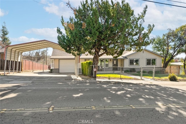 view of front of home with a fenced front yard, concrete driveway, and a carport