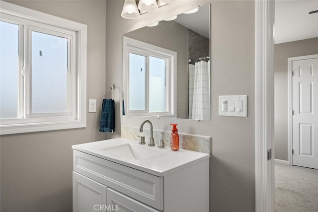 bathroom with plenty of natural light, walk in shower, vanity, and a notable chandelier