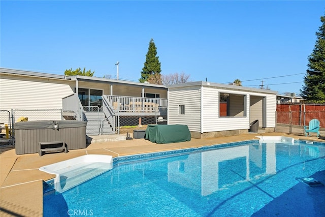 rear view of property with a swimming pool with hot tub