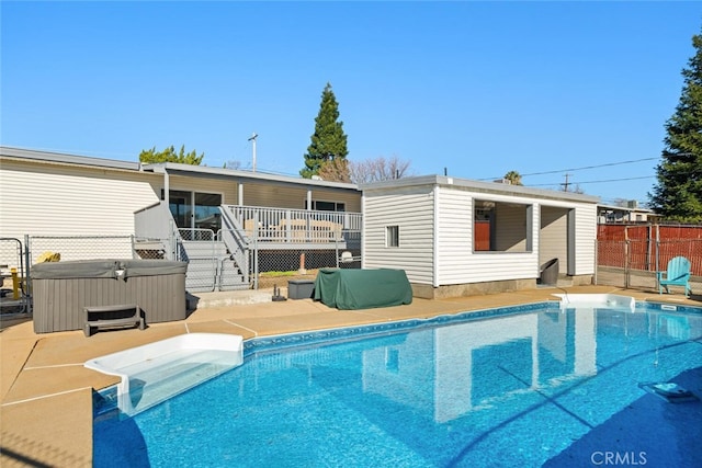 back of house featuring a fenced in pool, fence, a deck, and a hot tub