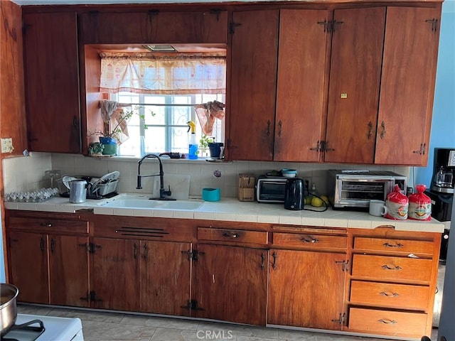 kitchen featuring tile counters, sink, and backsplash