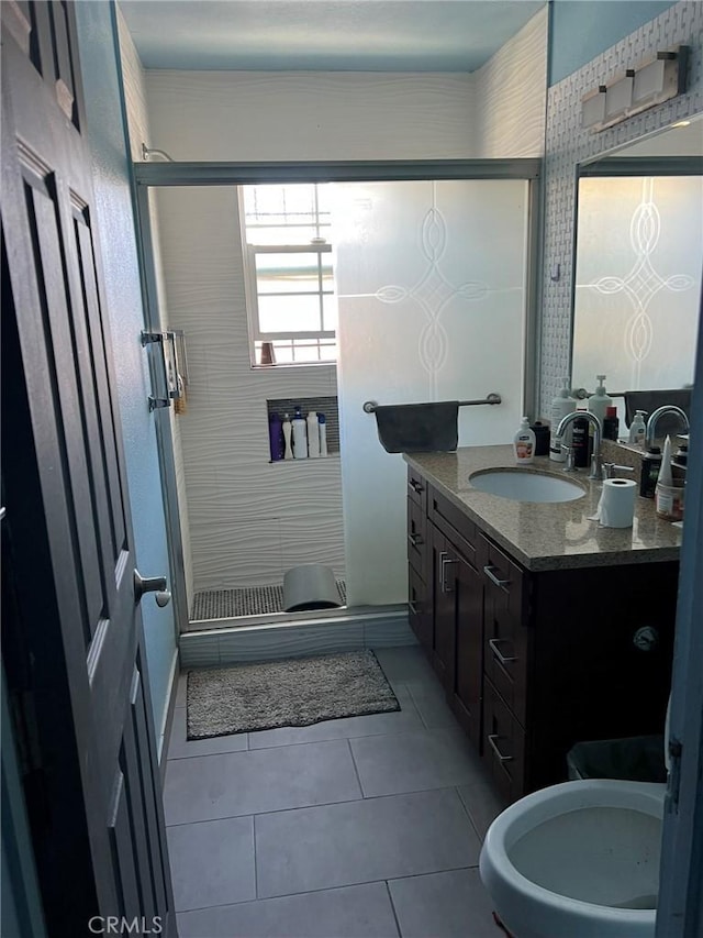 bathroom with walk in shower, vanity, and tile patterned flooring