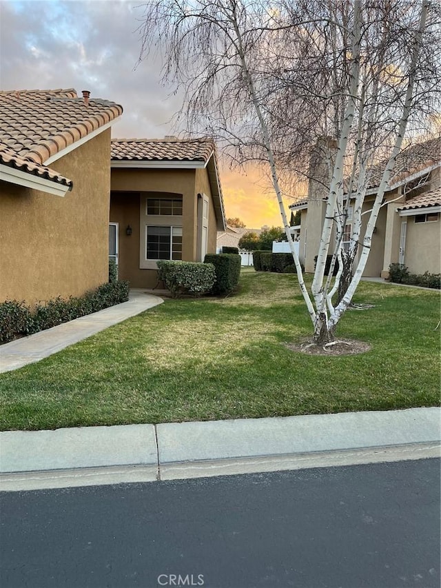 property exterior at dusk with a yard