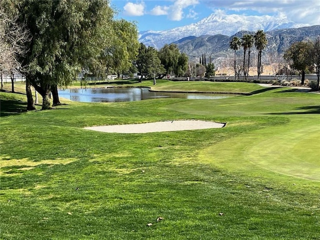 view of community featuring a water and mountain view and a yard