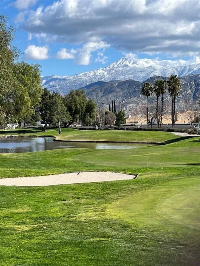 view of community featuring a water and mountain view and a yard