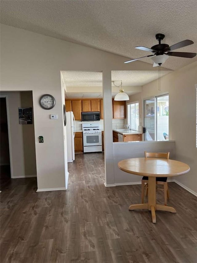 kitchen featuring ceiling fan, backsplash, white appliances, lofted ceiling, and sink