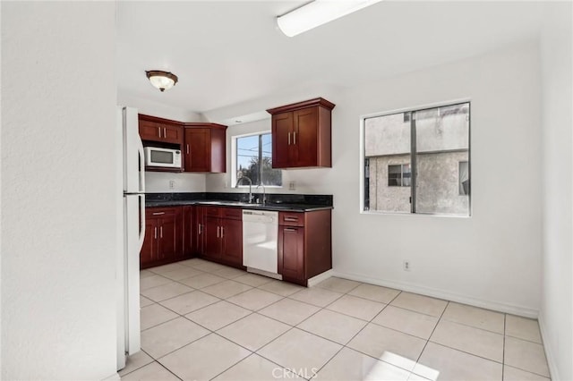 kitchen with sink, white appliances, and light tile patterned flooring