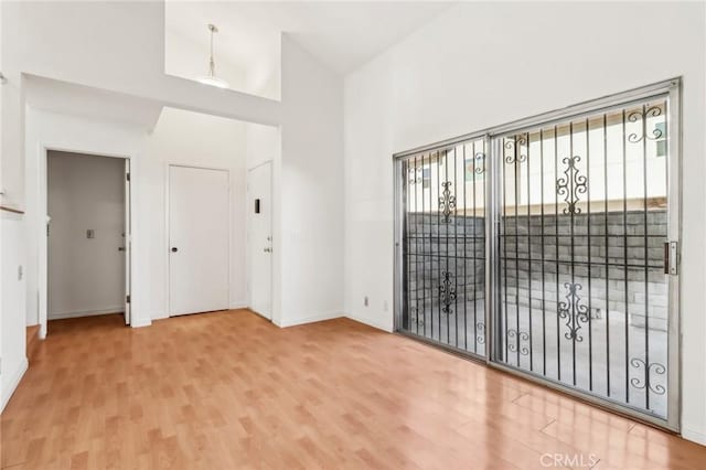 empty room featuring vaulted ceiling and hardwood / wood-style flooring