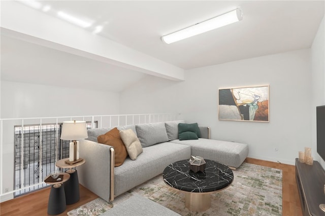 living room featuring vaulted ceiling with beams and hardwood / wood-style flooring