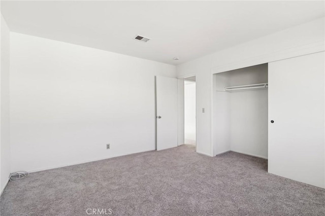 unfurnished bedroom with a closet and carpet flooring