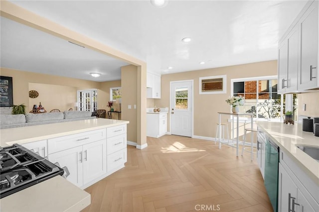 kitchen with light parquet flooring, white cabinets, and dishwasher