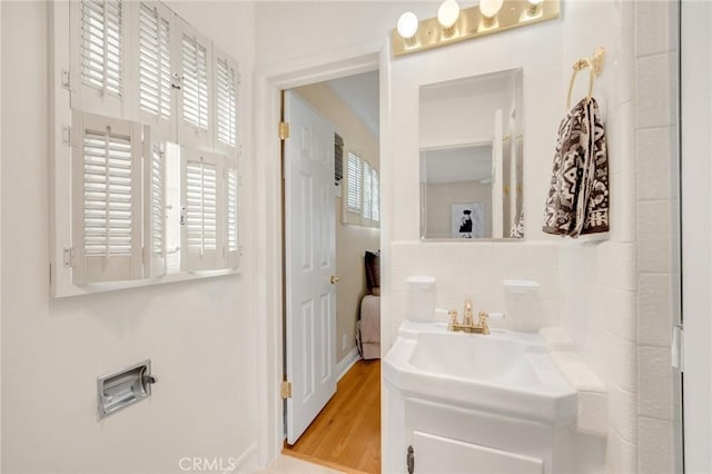 bathroom featuring decorative backsplash and hardwood / wood-style floors