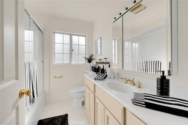 full bathroom featuring toilet, tile patterned flooring, enclosed tub / shower combo, and vanity