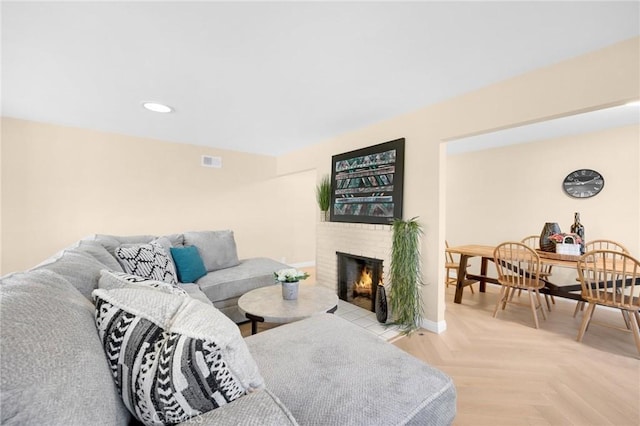 living room featuring light parquet flooring and a brick fireplace