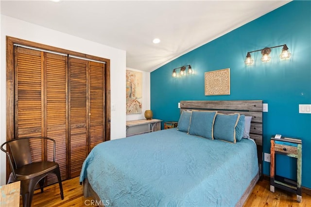 bedroom featuring hardwood / wood-style floors, a closet, and vaulted ceiling