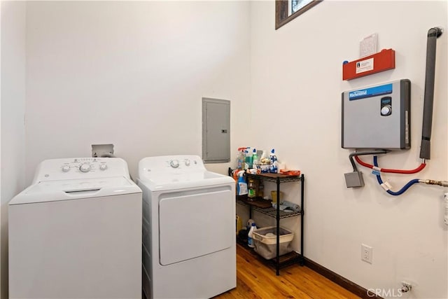 laundry area with electric panel, light hardwood / wood-style floors, and independent washer and dryer