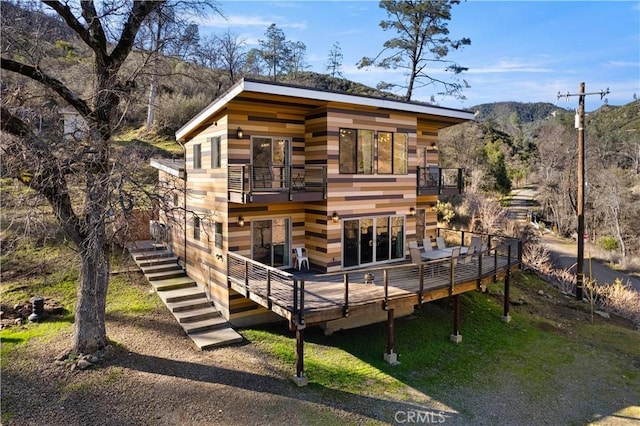 rear view of house featuring a deck with mountain view