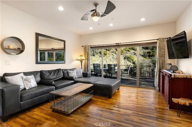 living room with ceiling fan and dark hardwood / wood-style flooring