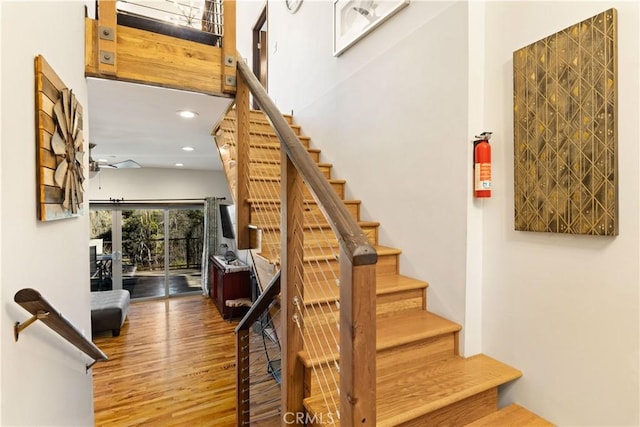 stairway with ceiling fan and hardwood / wood-style floors