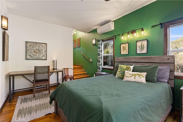 bedroom with hardwood / wood-style flooring and a wall mounted air conditioner