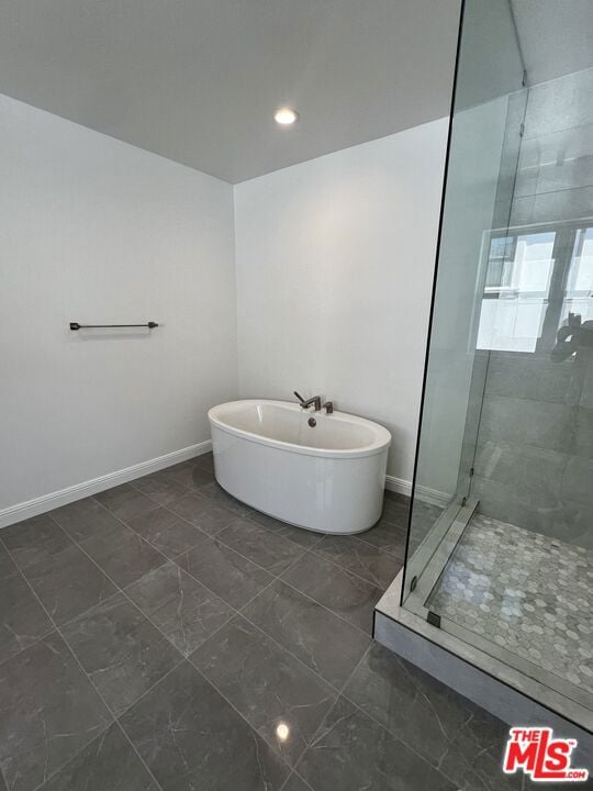 bathroom featuring shower with separate bathtub