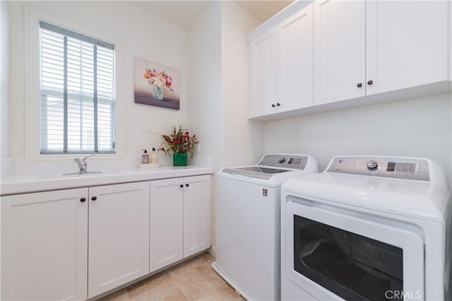 washroom with cabinets, independent washer and dryer, plenty of natural light, and sink